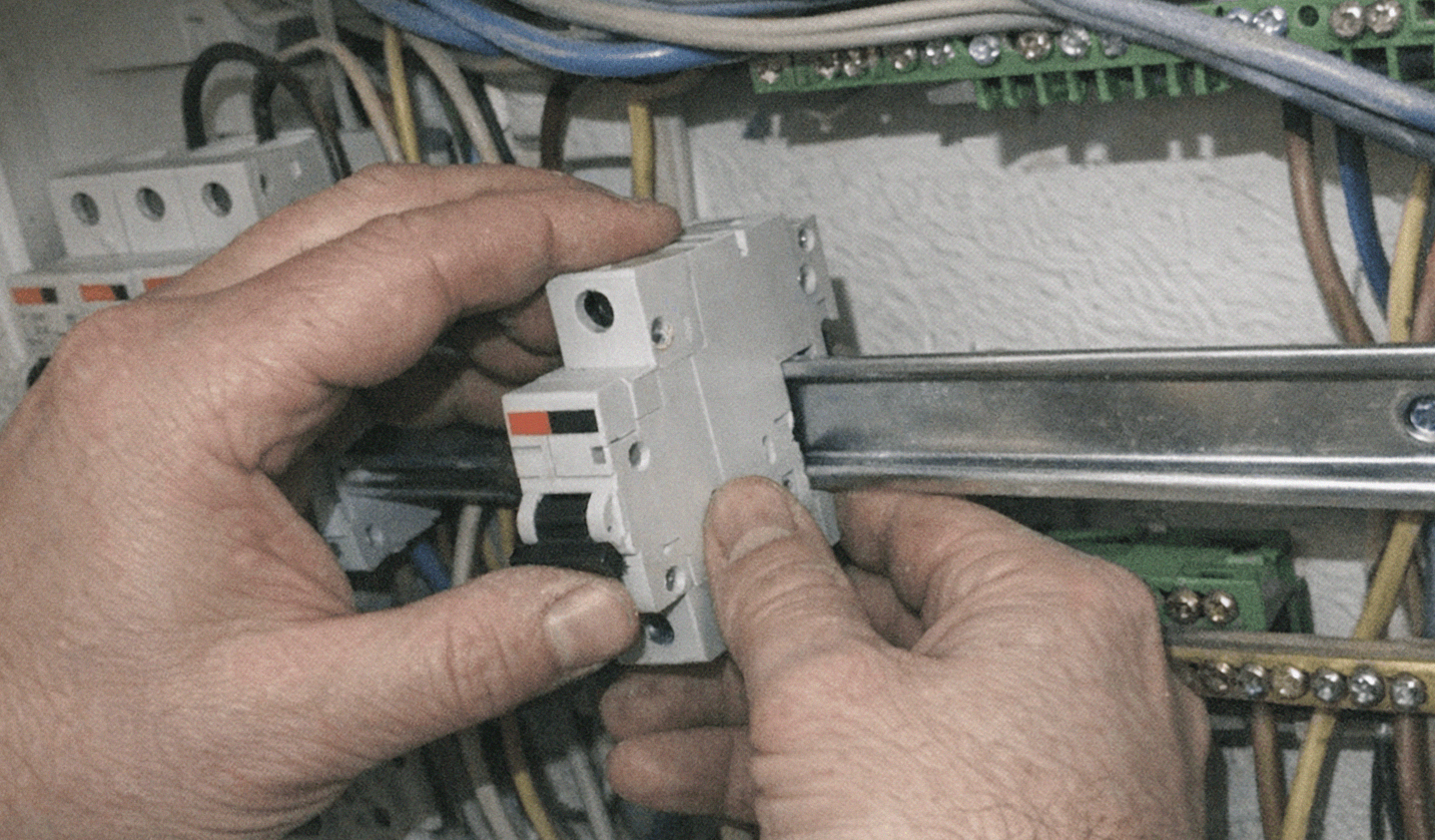 Elektriker prüft einen geöffneten Sicherungskasten bei einer geplanten Modernisierung der Elektroinstallation in einem Wohnhaus